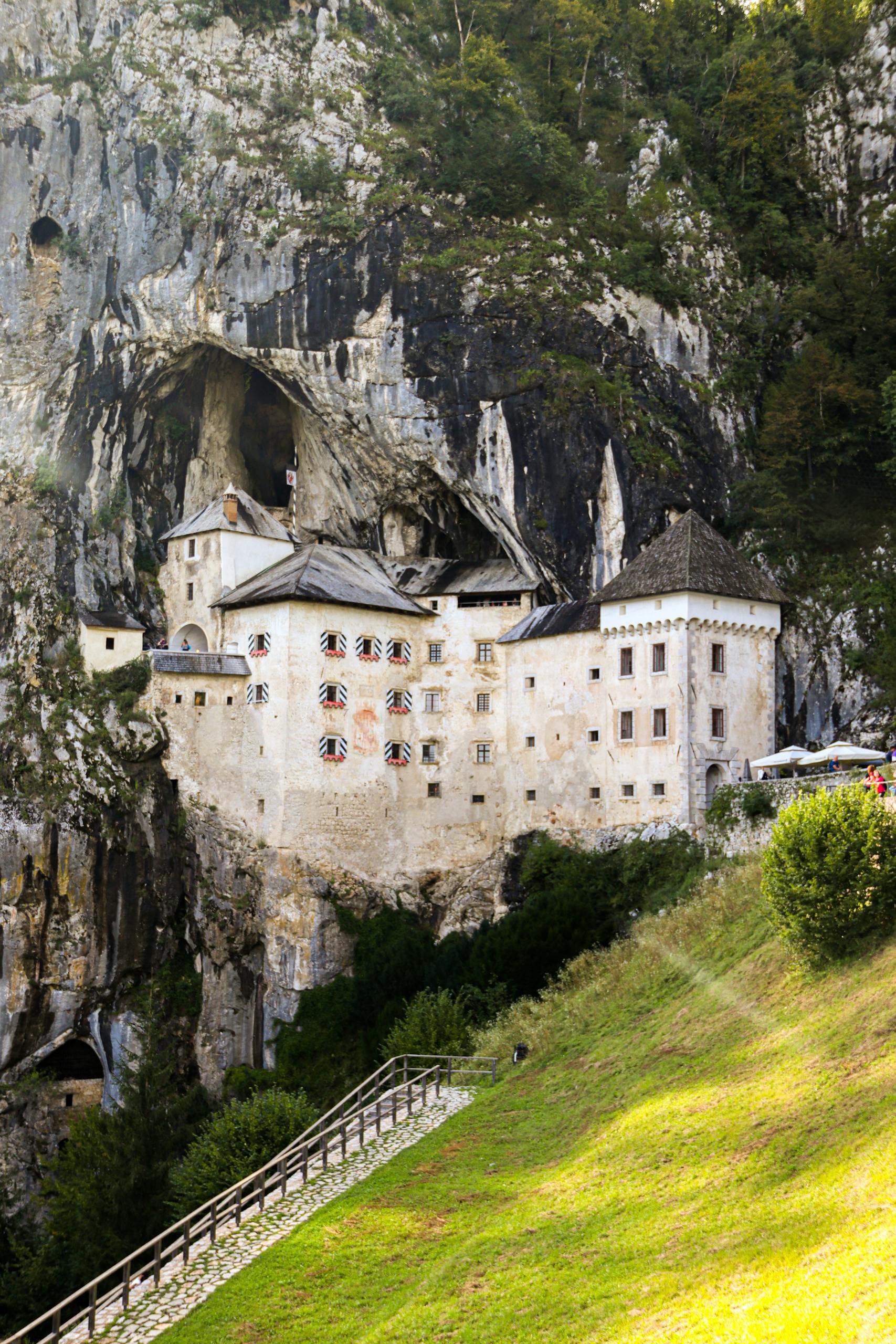 Explore a unique medieval castle nestled into a towering cliffside, merging nature and architecture.