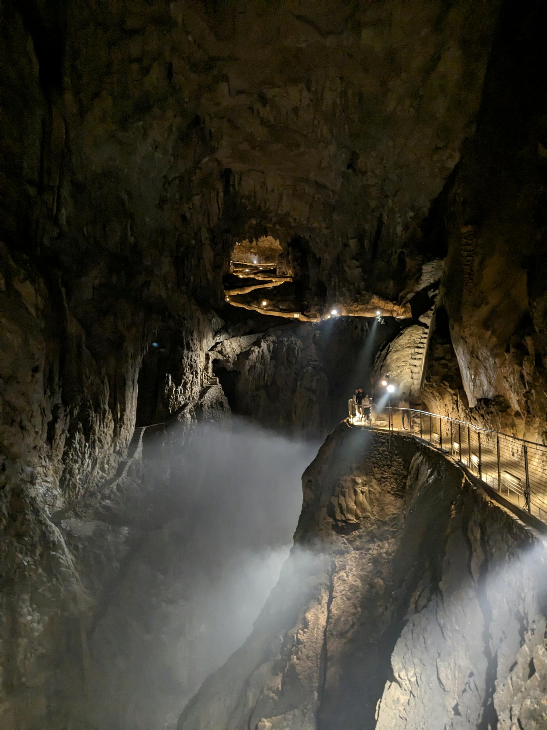 Explore the dramatic Skocjan Caves in Slovenia, featuring illuminated rock formations and pedestrian walkways.