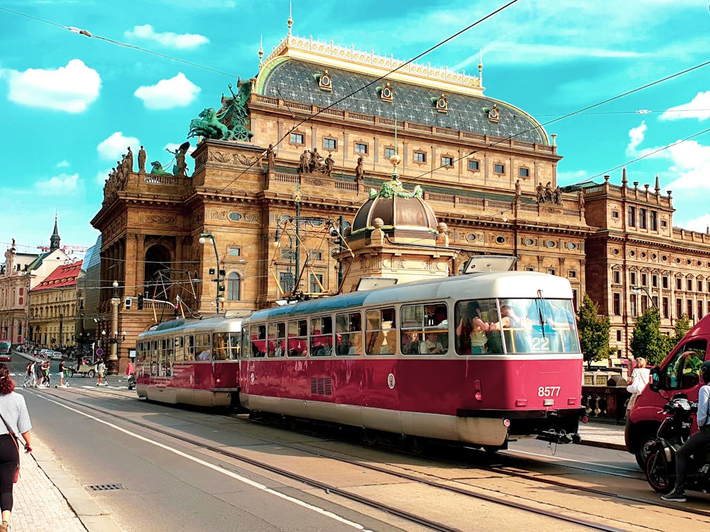 Red tram passes by the iconic National Theatre in the heart of Prague, Czechia.