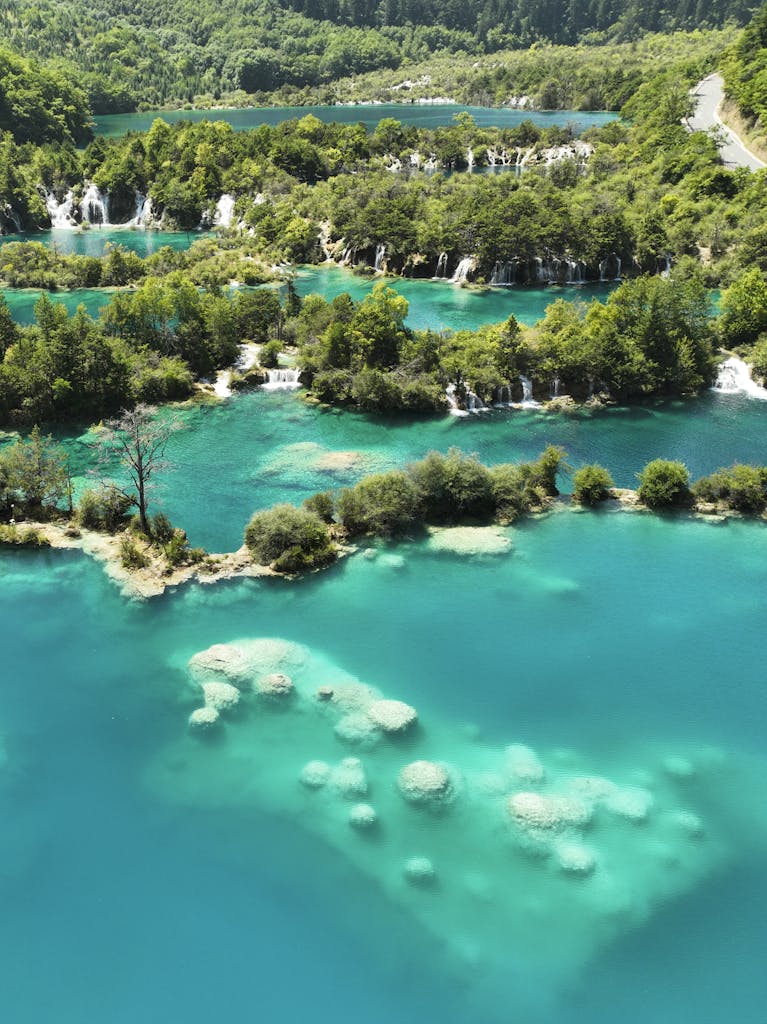 Stunning aerial shot of vibrant turquoise lakes and lush forests at Plitvice Lakes National Park.